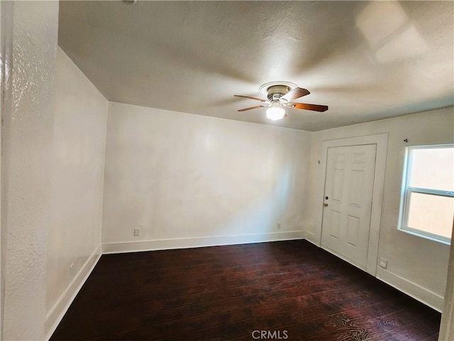 1210 W Manchester Ave, Los Angeles, CA 90044 - spare room featuring dark wood-type flooring, ceiling fan, and baseboards