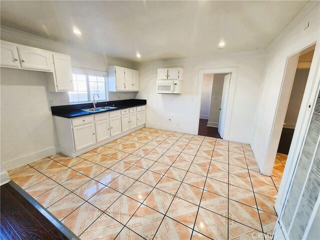 1210 W Manchester Ave, Los Angeles, CA 90044 - kitchen with a sink, white cabinetry, light tile patterned floors, a heating unit, and baseboards