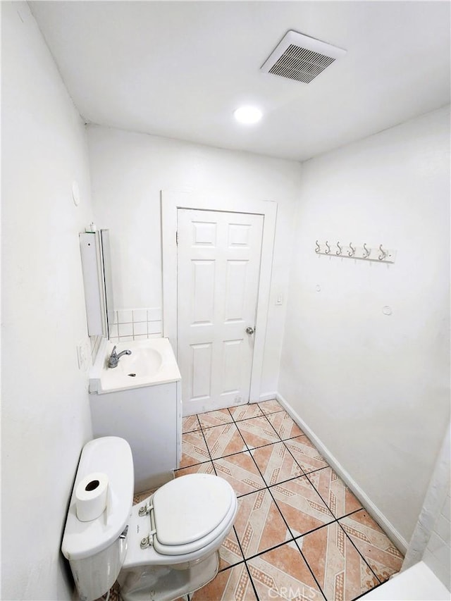 1210 W Manchester Ave, Los Angeles, CA 90044 - bathroom with toilet, tile patterned floors, baseboards, and vanity