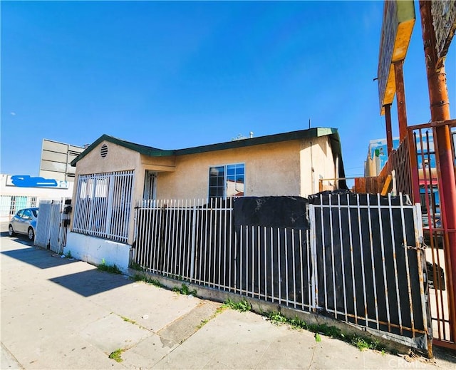 1210 W Manchester Ave, Los Angeles, CA 90044 - view of front of home featuring a fenced front yard and stucco siding