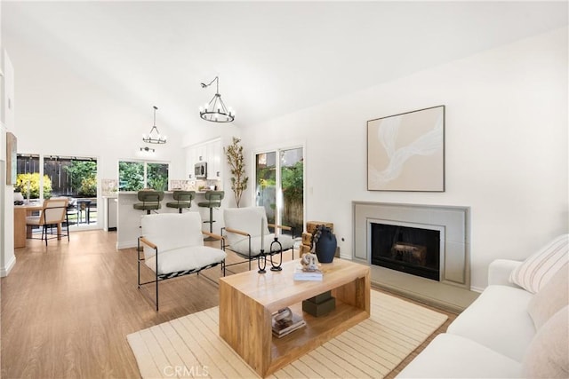 9 Via Olorosa, Rancho Santa Margarita, CA 92688 - living room with a fireplace with raised hearth, a chandelier, healthy amount of natural light, light wood-type flooring, and high vaulted ceiling