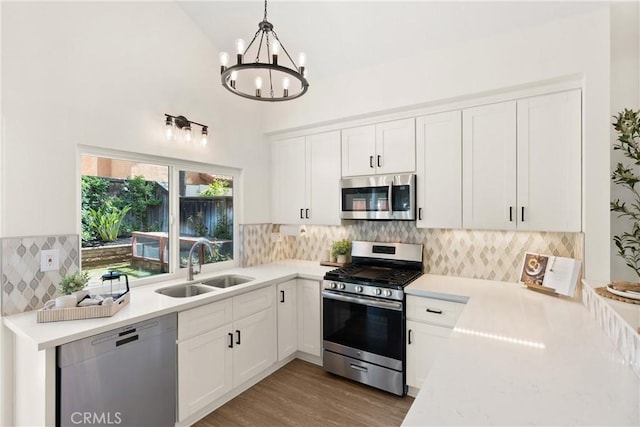 9 Via Olorosa, Rancho Santa Margarita, CA 92688 - kitchen featuring appliances with stainless steel finishes, a sink, light countertops, a chandelier, and high vaulted ceiling
