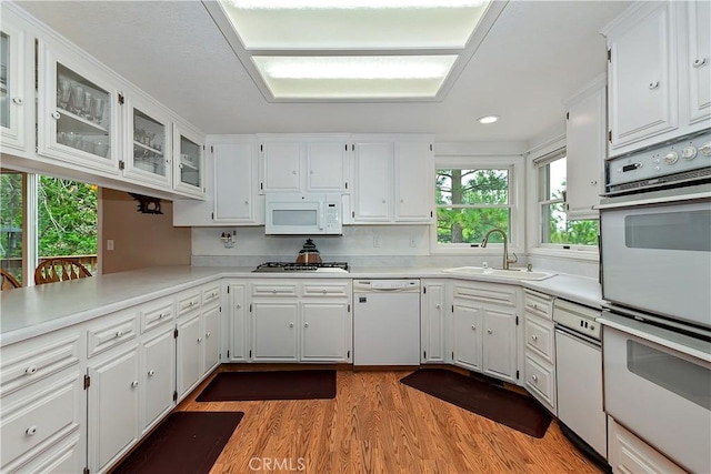 26349 Walnut Hills Dr, Lake Arrowhead, CA 92391 - kitchen featuring white appliances, a sink, wood finished floors, white cabinetry, and light countertops