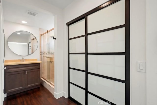 full bathroom with a shower stall, wood finished floors, vanity, recessed lighting, and baseboards