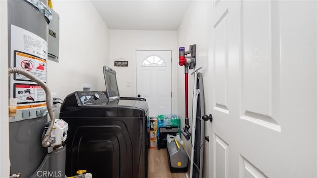 washroom with independent washer and dryer, wood finished floors, and gas water heater