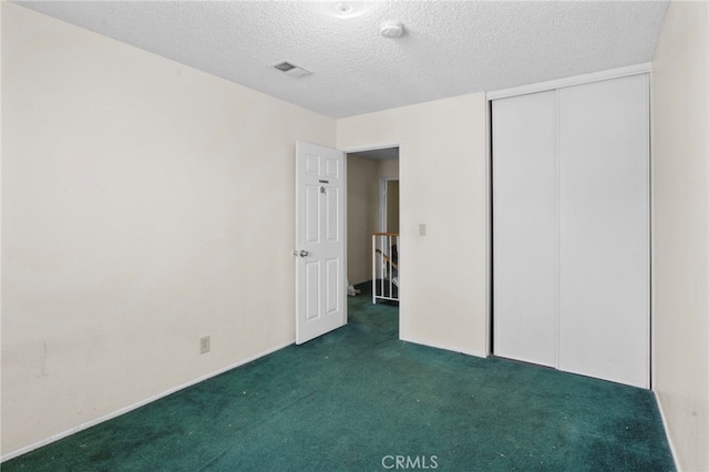 unfurnished bedroom featuring carpet floors, a textured ceiling, and a closet