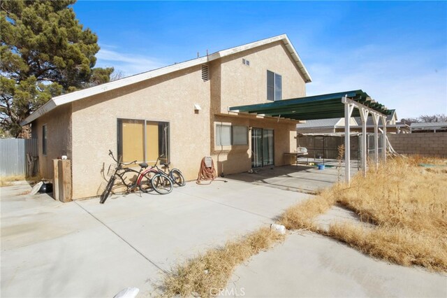 back of property featuring stucco siding, fence, a patio area, and a pergola
