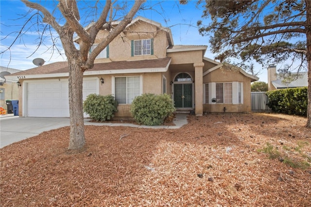 traditional home with concrete driveway, stucco siding, an attached garage, and fence