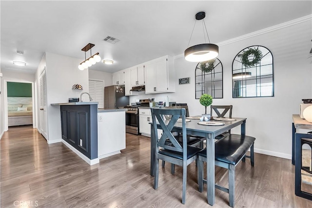 dining room with baseboards, dark wood-style flooring, and ornamental molding