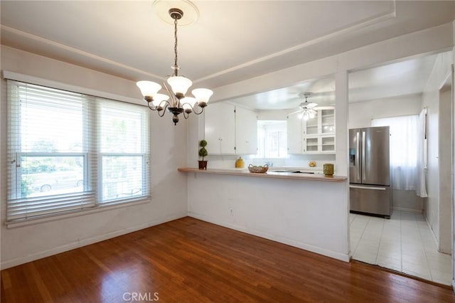 1315 S Walker Ave, San Pedro, CA 90731 - kitchen with stainless steel fridge, a chandelier, light wood-style floors, white cabinets, and a peninsula