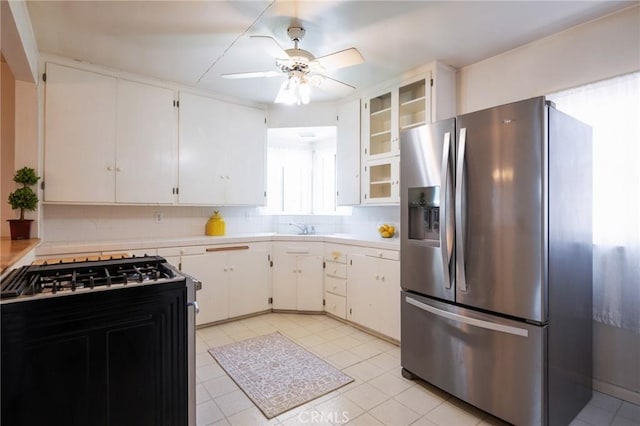 1315 S Walker Ave, San Pedro, CA 90731 - kitchen with stainless steel fridge, gas stove, a ceiling fan, light countertops, and light tile patterned floors