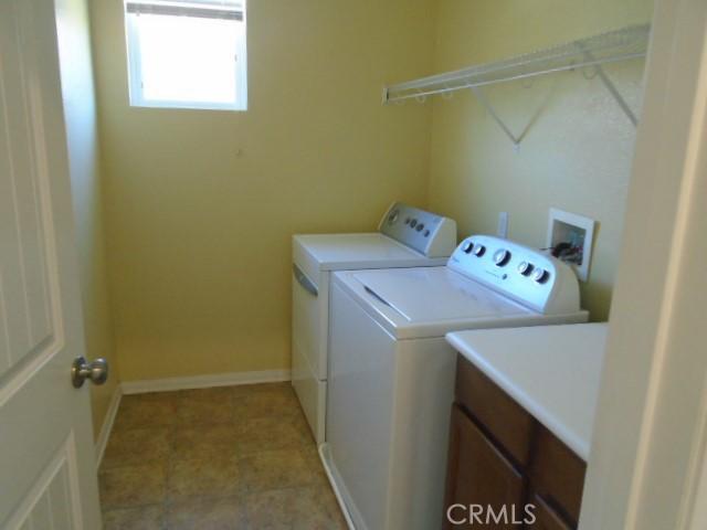 29221 Loden Cir, Menifee, CA 92584 - laundry area with washing machine and clothes dryer, cabinet space, and baseboards