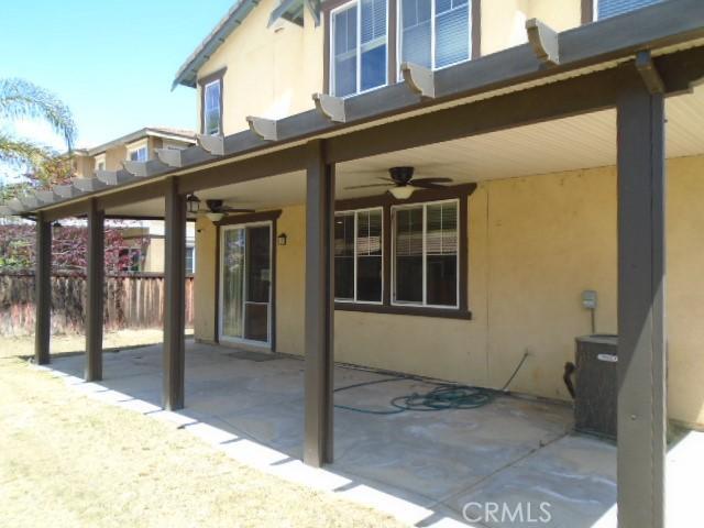 29221 Loden Cir, Menifee, CA 92584 - rear view of property featuring stucco siding, a ceiling fan, a patio, and fence