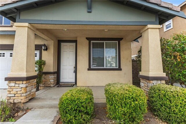 29221 Loden Cir, Menifee, CA 92584 - entrance to property featuring a porch, stucco siding, and stone siding