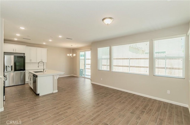 1123 Vanguard Way W, Madera, CA 93636 - kitchen with stainless steel appliances, a sink, baseboards, a chandelier, and light countertops