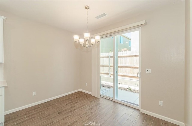 1123 Vanguard Way W, Madera, CA 93636 - empty room featuring wood finished floors, a chandelier, and baseboards