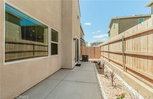 1123 Vanguard Way W, Madera, CA 93636 - view of side of property with stucco siding, a patio, a fenced backyard, and central AC