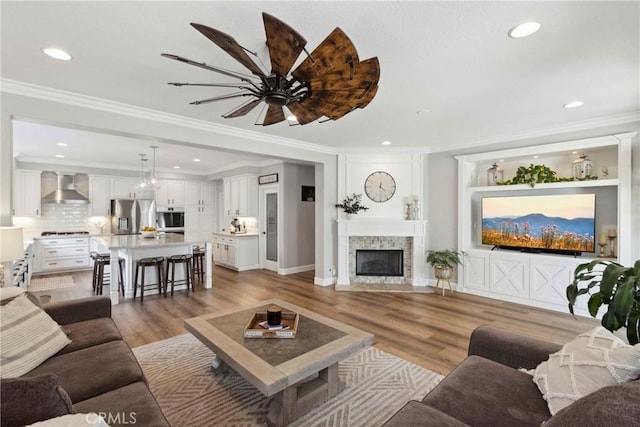32840 Northshire Cir, Temecula, CA 92592 - living room with a fireplace, light wood-style flooring, ceiling fan, recessed lighting, and ornamental molding