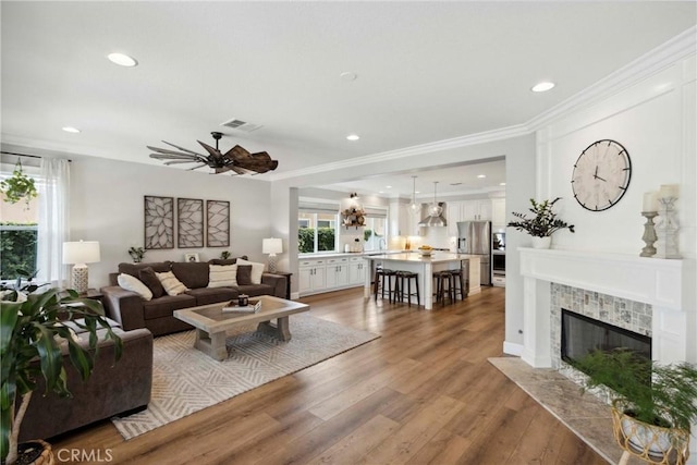 32840 Northshire Cir, Temecula, CA 92592 - living area featuring a ceiling fan, light wood-style flooring, recessed lighting, a tile fireplace, and crown molding