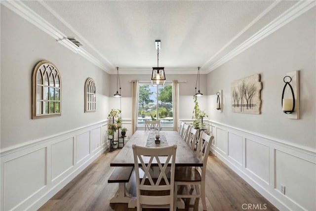 32840 Northshire Cir, Temecula, CA 92592 - dining space featuring a decorative wall, wood finished floors, crown molding, and wainscoting