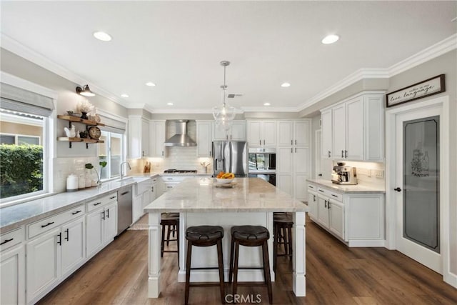 32840 Northshire Cir, Temecula, CA 92592 - kitchen with stainless steel appliances, wall chimney exhaust hood, white cabinetry, a breakfast bar area, and a kitchen island