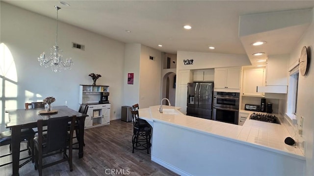 23770 Waterleaf Cir, Moreno Valley, CA 92557 - kitchen with black fridge with ice dispenser, double oven, a sink, dark wood finished floors, and gas cooktop