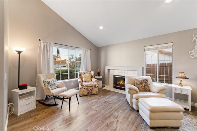 23770 Waterleaf Cir, Moreno Valley, CA 92557 - living area with wood finished floors, a tiled fireplace, high vaulted ceiling, and recessed lighting