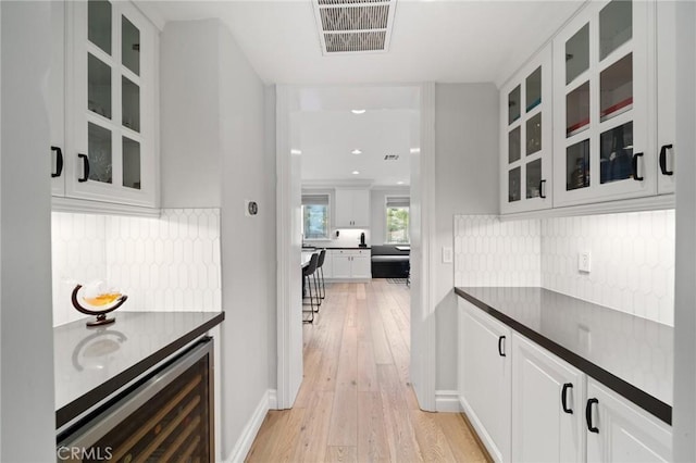 2583 N Skytop Ct, Orange, CA 92867 - bar featuring beverage cooler, light wood-style floors, and tasteful backsplash