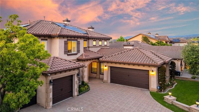 2583 N Skytop Ct, Orange, CA 92867 - mediterranean / spanish home with an attached garage, solar panels, decorative driveway, a tiled roof, and stucco siding