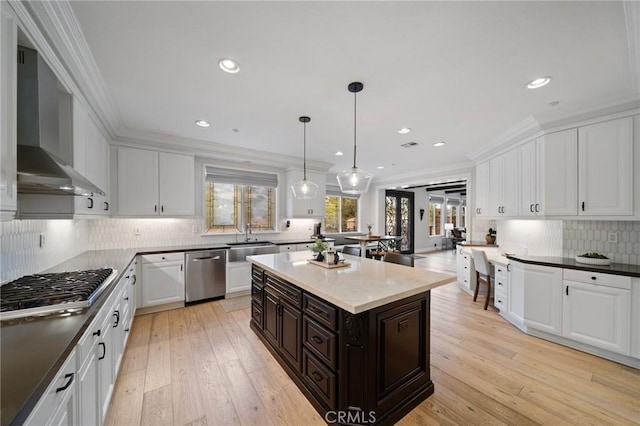 2583 N Skytop Ct, Orange, CA 92867 - kitchen with appliances with stainless steel finishes, wall chimney range hood, white cabinetry, a sink, and decorative backsplash