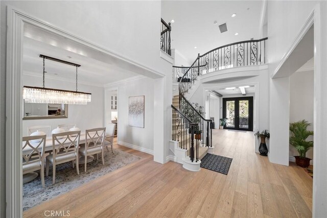 2583 N Skytop Ct, Orange, CA 92867 - foyer entrance featuring stairs, wood finished floors, a towering ceiling, a chandelier, and french doors