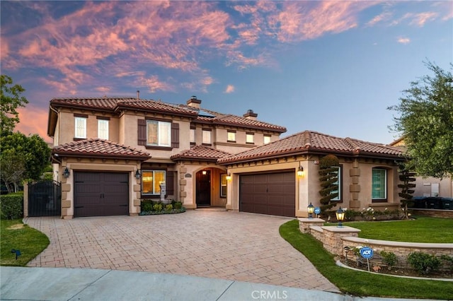 2583 N Skytop Ct, Orange, CA 92867 - mediterranean / spanish-style house featuring a garage, a chimney, decorative driveway, and stucco siding