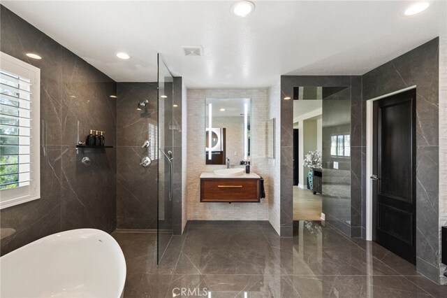 46397 Kohinoor Way, Temecula, CA 92592 - bathroom featuring a soaking tub, walk in shower, healthy amount of natural light, vanity, and tile walls