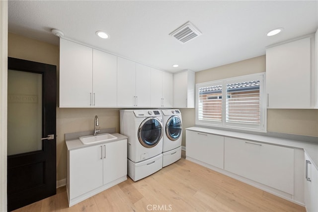 46397 Kohinoor Way, Temecula, CA 92592 - laundry area with washing machine and clothes dryer, light wood-style flooring, cabinet space, and recessed lighting