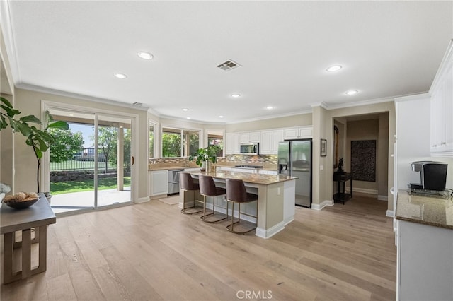 46397 Kohinoor Way, Temecula, CA 92592 - kitchen featuring appliances with stainless steel finishes, crown molding, decorative backsplash, light wood-type flooring, and stone counters