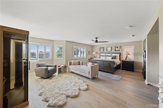 46397 Kohinoor Way, Temecula, CA 92592 - bedroom featuring multiple windows, wood finished floors, a textured ceiling, and a ceiling fan