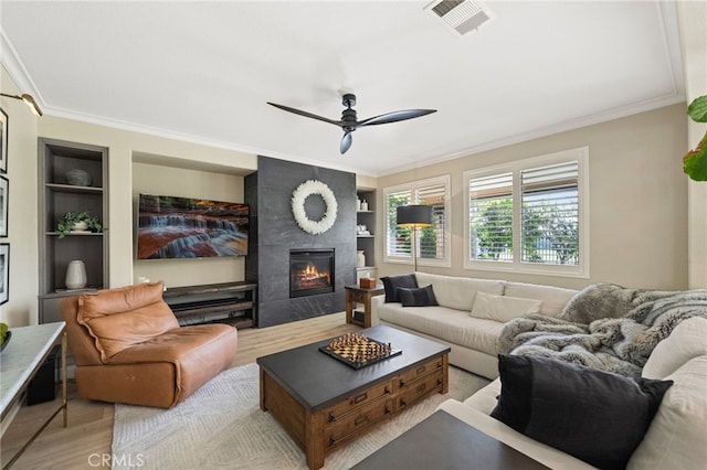 46397 Kohinoor Way, Temecula, CA 92592 - living area with built in shelves, crown molding, wood finished floors, a fireplace, and ceiling fan