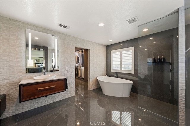 46397 Kohinoor Way, Temecula, CA 92592 - full bath featuring a soaking tub, walk in shower, vanity, tile walls, and recessed lighting