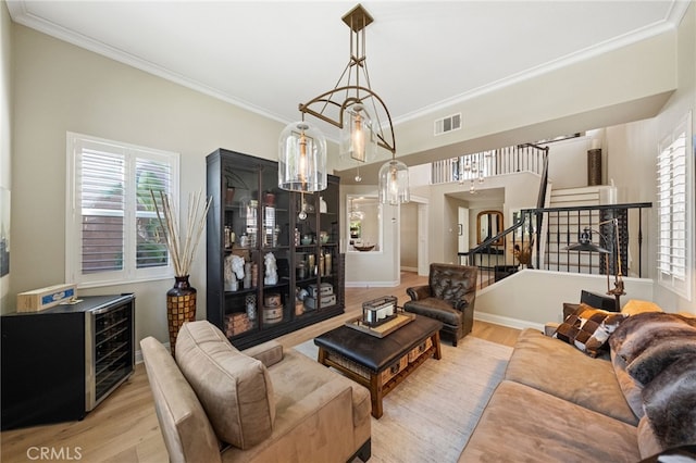 46397 Kohinoor Way, Temecula, CA 92592 - living room featuring light wood-style floors, healthy amount of natural light, ornamental molding, and stairway