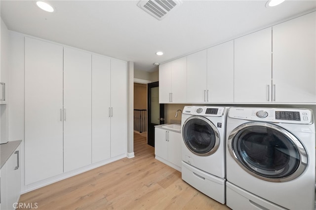 46397 Kohinoor Way, Temecula, CA 92592 - washroom with washing machine and dryer, light wood-type flooring, cabinet space, and recessed lighting