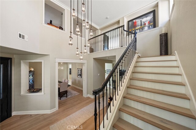 46397 Kohinoor Way, Temecula, CA 92592 - stairway featuring wood finished floors, a chandelier, and a towering ceiling