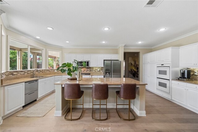 46397 Kohinoor Way, Temecula, CA 92592 - kitchen featuring appliances with stainless steel finishes, a kitchen island, tasteful backsplash, crown molding, and recessed lighting