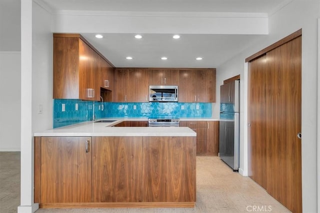 kitchen featuring stainless steel appliances, a sink, brown cabinetry, light countertops, and backsplash