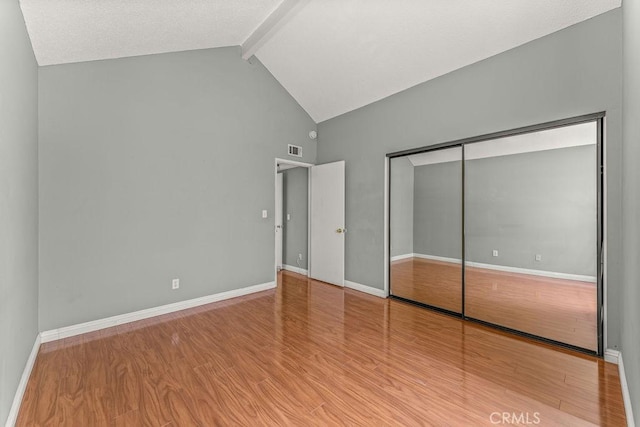 628 Daisy Ave Unit 420, Long Beach, CA 90802 - unfurnished bedroom with beam ceiling, wood finished floors, a closet, baseboards, and high vaulted ceiling