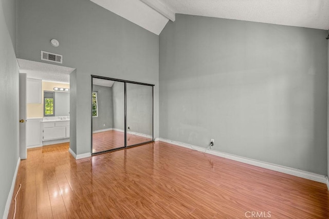 628 Daisy Ave Unit 420, Long Beach, CA 90802 - unfurnished bedroom featuring light wood-type flooring, high vaulted ceiling, beam ceiling, a closet, and baseboards