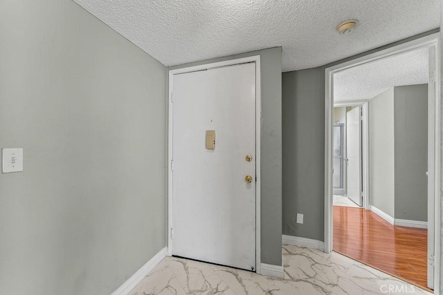 628 Daisy Ave Unit 420, Long Beach, CA 90802 - foyer with light marble finish floors, a textured ceiling, and baseboards