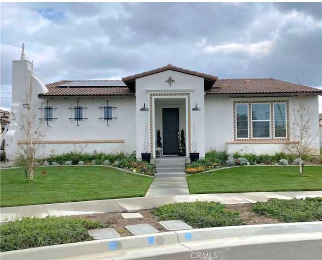 4511 S Luna Privado, Ontario, CA 91761 - mediterranean / spanish house featuring solar panels, a front lawn, and stucco siding