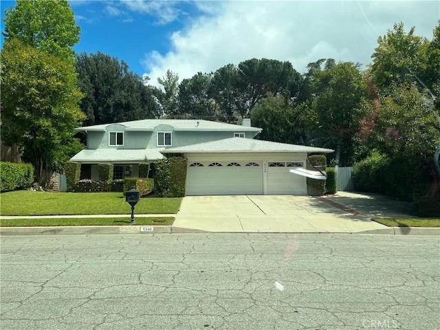5340 Edgeware Dr, Calabasas, CA 91301 - view of front of property with a garage, a front lawn, driveway, and view of wooded area