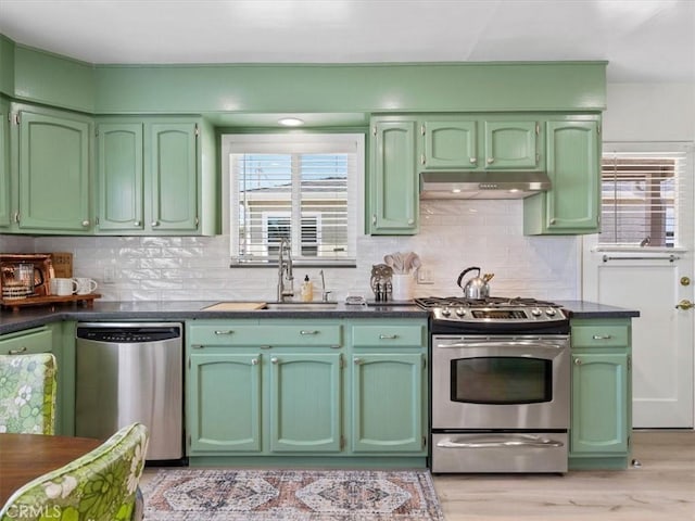 715 Bennett Ave, Arroyo Grande, CA 93420 - kitchen with stainless steel appliances, green cabinetry, under cabinet range hood, a sink, and dark countertops