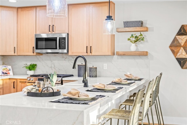 kitchen featuring stainless steel microwave, light brown cabinetry, and light countertops